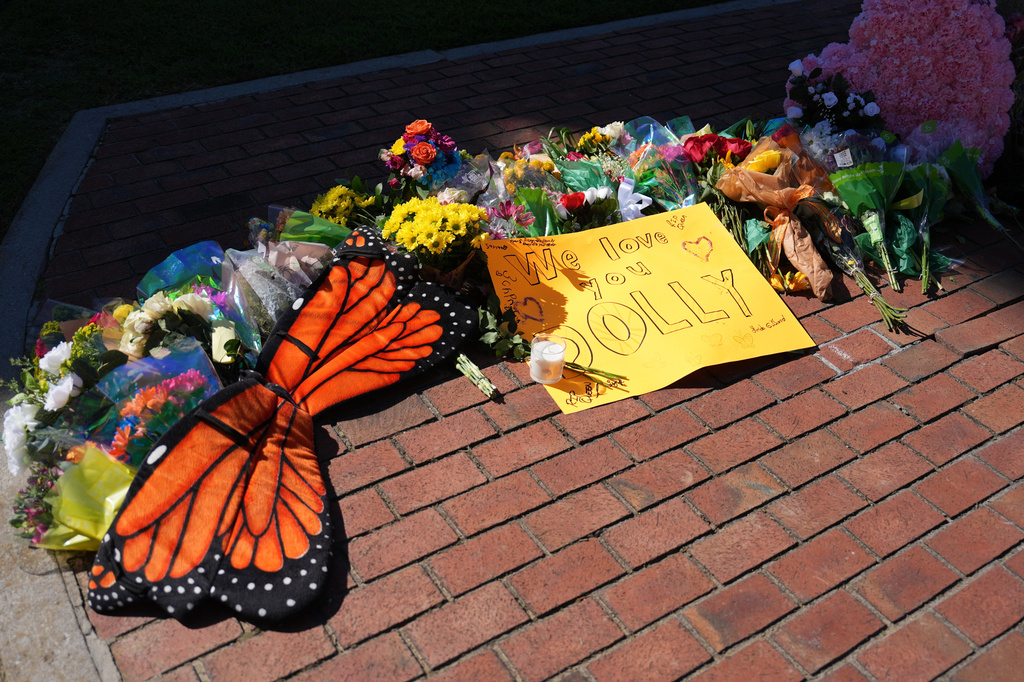 Flowers and monarch butterfly wings form part of a makeshift memorial honoring Dolly Parton in Sevierville, Tenn., Tuesday, Aug. 25, 2026. (AP Photo/Camden Hall)