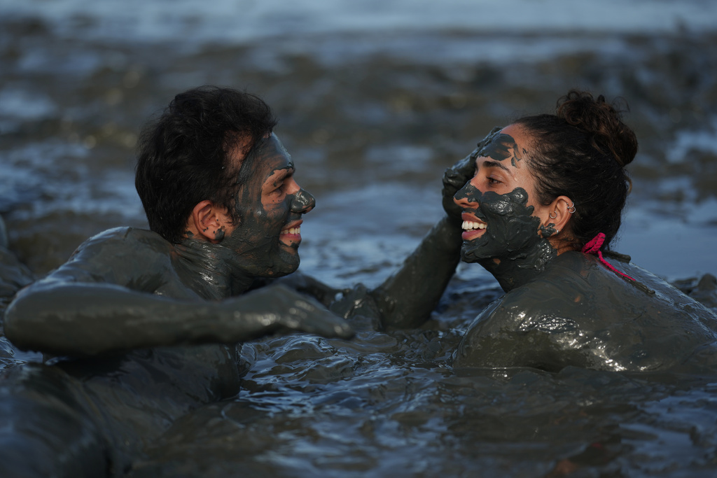 A man smears mud on a fellow reveler during the Mud Block carnival party in Paraty, Brazil, Saturday, Feb. 14, 2026. (AP Photo/Andre Penner)