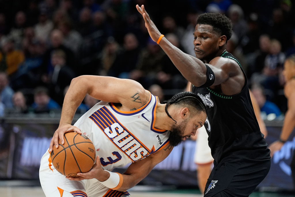 Phoenix Suns forward Dillon Brooks (3) handles the ball as Minnesota Timberwolves guard Anthony Edwards defends during the second half of an NBA basketball game, Monday, Dec. 8, 2025, in Minneapolis. (AP Photo/Abbie Parr)