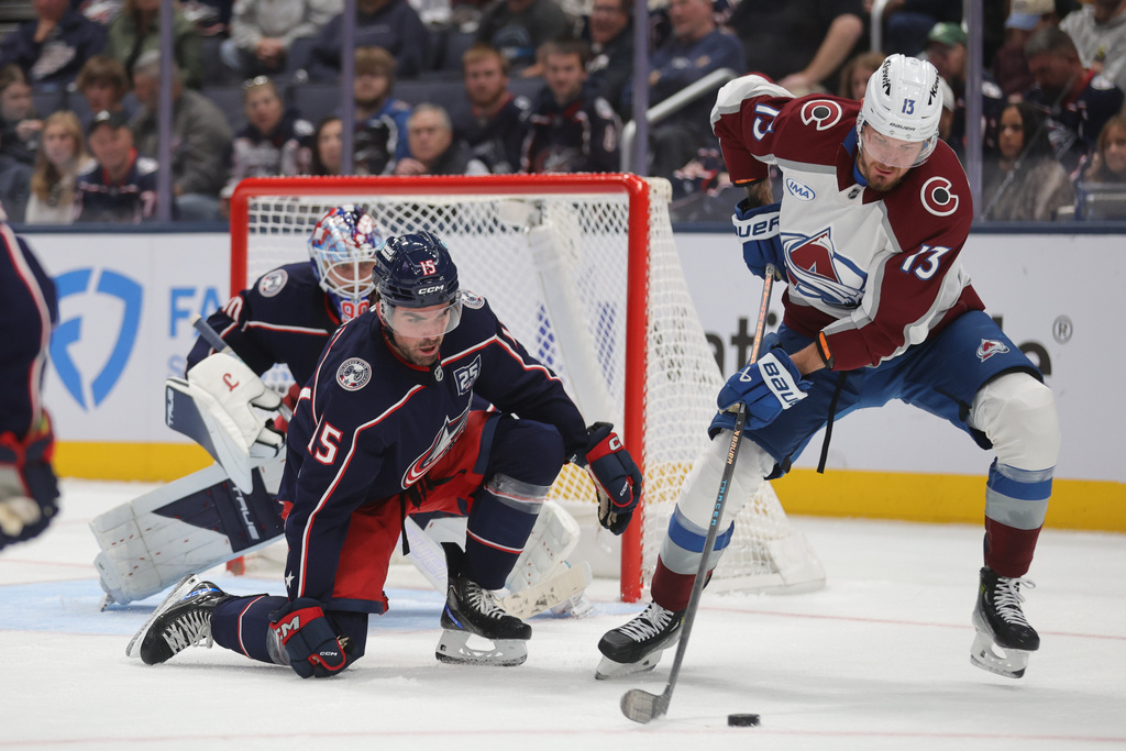 Colorado Avalanche forward Valeri Nichushkin, right, controls the puck in front of Columbus Blue Jackets defenseman Dante Fabbro, center, and goalie Elvis Merzlikins, during the second period of an NHL hockey game in Columbus, Ohio, Thursday, Oct. 16, 2025. (AP Photo/Paul Vernon)