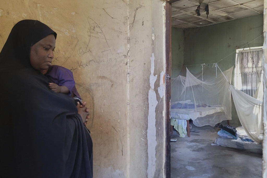Amina Hassan, wife of the vice principal of the Government Girls Comprehensive Secondary School, where gunmen on Monday attacked the school dormitory, abducted schoolgirls and killed her husband, stands in front of the room where he was killed, in Kebbi, Nigeria, Tuesday, Nov. 18, 2025. (AP Photo/Tunde Omolehin)