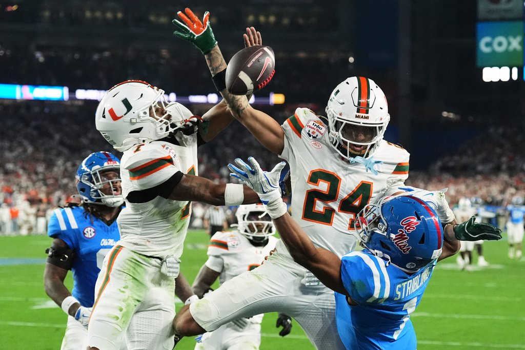 Miami safety Zechariah Poyser (7) and defensive back Ethan O'Connor (24) break up a pass intended for Mississippi wide receiver De'zhaun Stribling (1) during the second half the Fiesta Bowl NCAA college football playoff semifinal game, Thursday, Jan. 8, 2026, in Glendale, Ariz. (AP Photo/Ross D. Franklin)