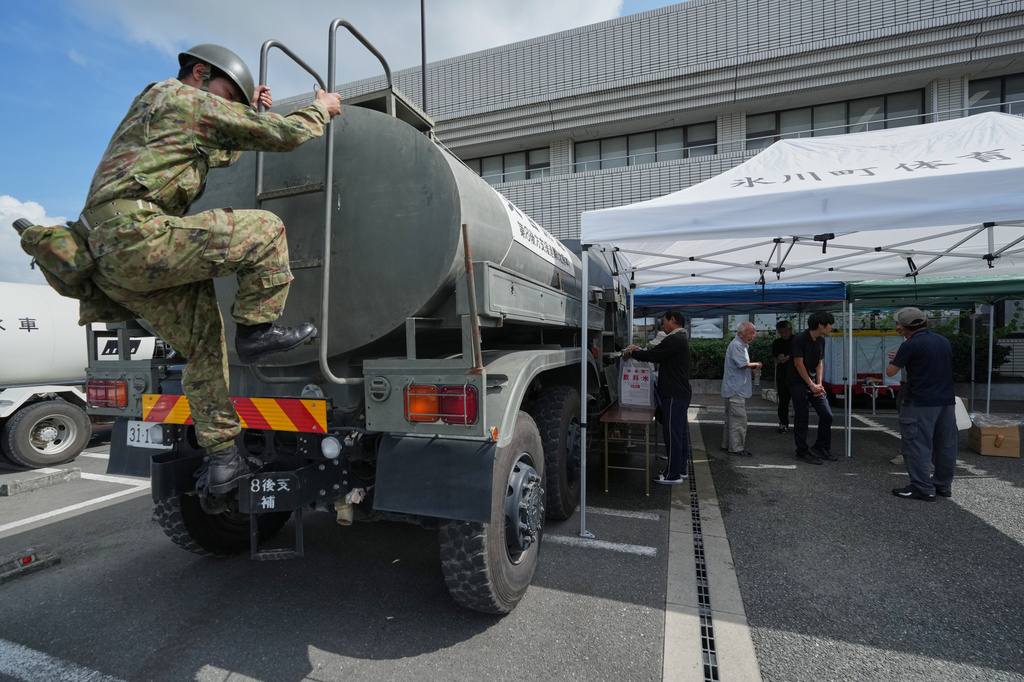 A Self-Defense Force member checks a water supply vehicle providing water to residents affected by an earthquake in Hikawa, Kumamoto Prefecture, southern Japan, Thursday, July 30, 2026. (AP Photo/Hiro Komae)