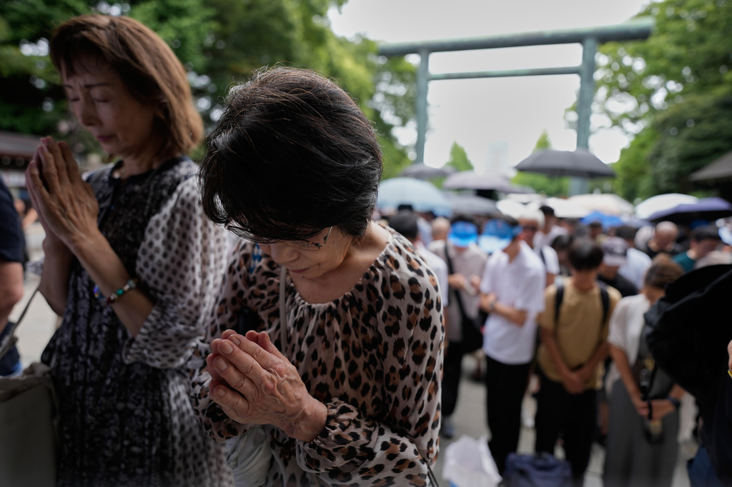 Visitors observe a moment of silence at Yasukuni Shrine, which honors Japan's war dead, including convicted war criminals, as the country marks the 81st anniversary of the end of World War II Saturday, Aug. 15, 2026, in Tokyo. (AP Photo/Eugene Hoshiko)