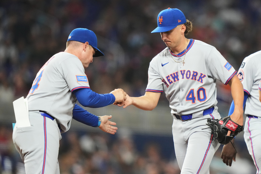 New York Mets starting pitcher Brandon Sproat (40) hands the ball to manager Carlos Mendoza, left, as he is relieved during the fifth inning of a baseball game against the Miami Marlins, Friday, Sept. 26, 2025, in Miami. (AP Photo/Lynne Sladky)