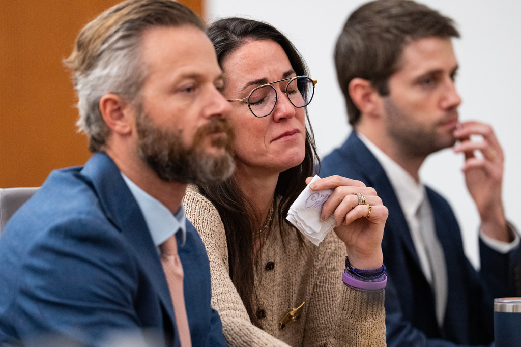 Holding a handkerchief embroidered with her daughter's name, CiCi Steward, who lost her 8-year-old daughter Cile Steward in the July 4 flood, listens to testimony alongside her husband, Will Steward, during a hearing on a suit against Camp Mystic in the 459th State District Court in Austin, Wednesday, April 15, 2026. (Mikala Compton/Austin American-Statesman via AP)