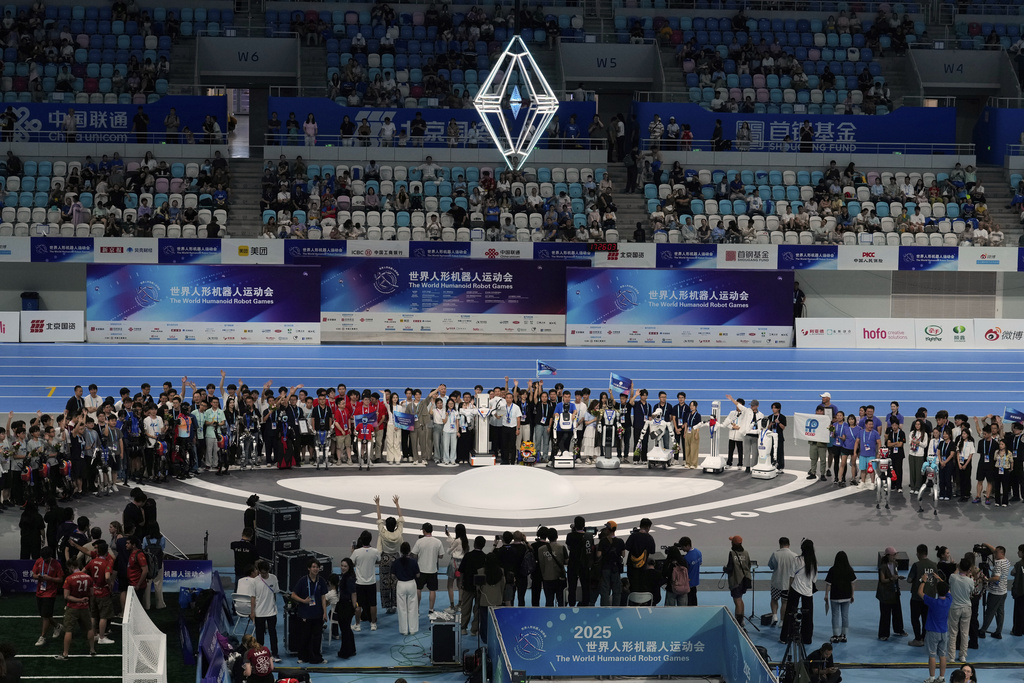 Winners from different games pose for celebratory photographs during the closing ceremony of the World Humanoid Robot Games held in Beijing, China, Sunday, Aug. 17, 2025. (AP Photo/Mahesh Kumar A.)
