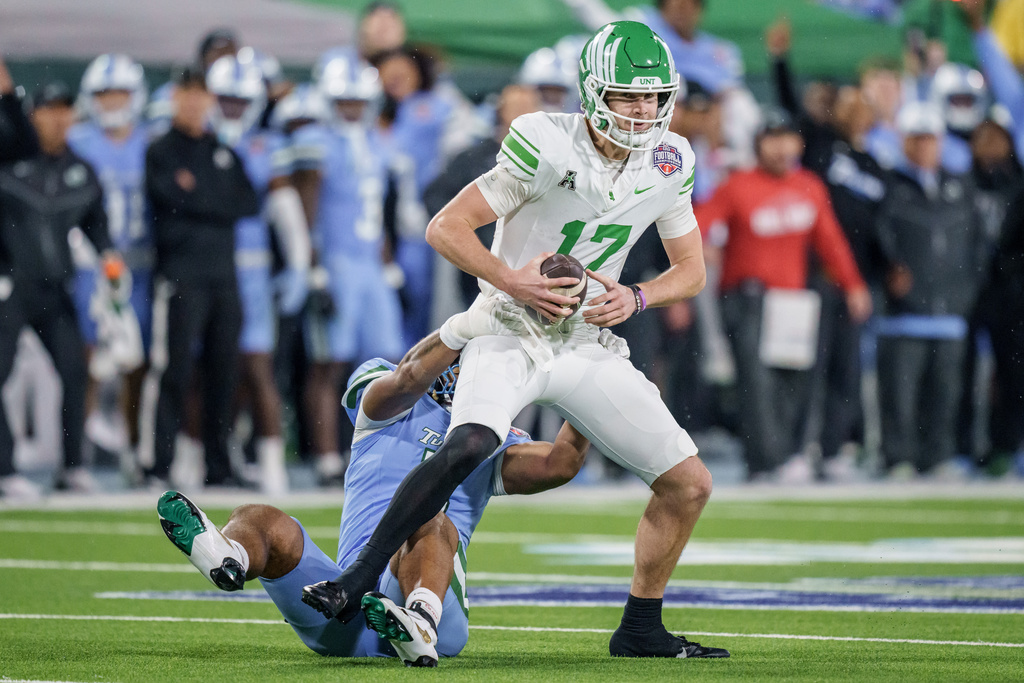 North Texas quarterback Drew Mestemaker (17) is sacked by Tulane linebacker Harvey Dyson, bottom left, during the first half of the American Conference championship NCAA college football game in New Orleans, Friday, Dec. 5, 2025. (AP Photo/Matthew Hinton)