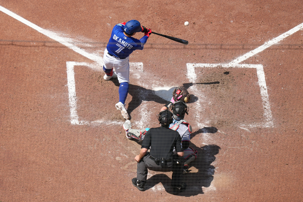 Toronto Blue Jays' Kazuma Okamoto (7) hits a solo home run in front of Miami Marlins catcher Liam Hicks (34) during the sixth inning of a baseball game in Toronto, Wednesday, May 27, 2026. (Chris Young/The Canadian Press via AP)