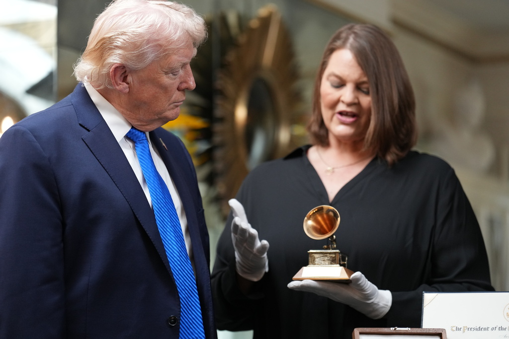 President Donald Trump is shown a Grammy award won by Elvis Presley in the living room at Graceland, Elvis Presley's historic estate, Monday, March 23, 2026, in Memphis, Tenn. (AP Photo/Mark Schiefelbein)