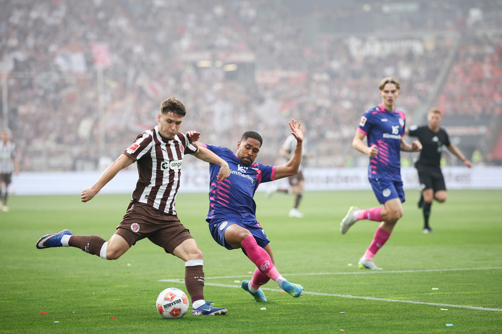 St. Pauli's Arkadiusz Pyrka, left, and Mainz's Phillipp Mwene battle for the ball during the German Bundesliga soccer match between FC St. Pauli and FSV Mainz 05 in Hamburg, Germany, Sunday, May 3, 2026. (Christian Charisius/dpa via AP)