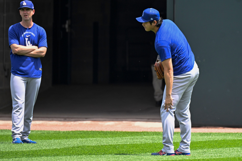 Los Angeles Dodgers two-way player Shohei Ohtani, from Japan, touches his knee before a baseball game against the Chicago White Sox, Saturday, June 13, 2026, in Chicago. (AP Photo/Matt Marton)