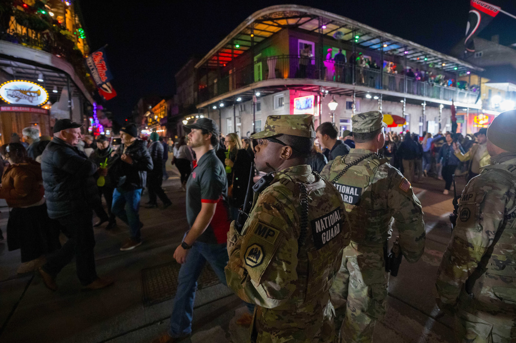 FILE - The National Guard and other uniformed members of law enforcement from federal, state, and local agencies patrol as New Year's Eve revelers walk on Bourbon Street in New Orleans, Dec. 31, 2025. (AP Photo/Matthew Hinton, File)