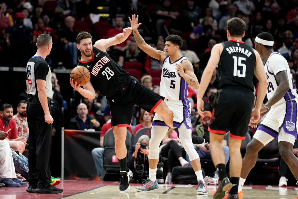 Houston Rockets center Alperen Sengun (28) falls over while trunk to pass as Sacramento Kings guard Nique Clifford (5) defends during the first half of an NBA basketball game Wednesday, Feb. 25, 2026, in Houston. (AP Photo/Eric Christian Smith)