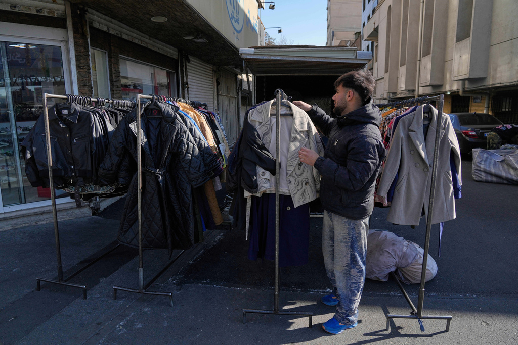A street vendor adjusts clothes for sale in downtown Tehran, Iran, Friday, Jan. 16, 2026. (AP Photo/Vahid Salemi)