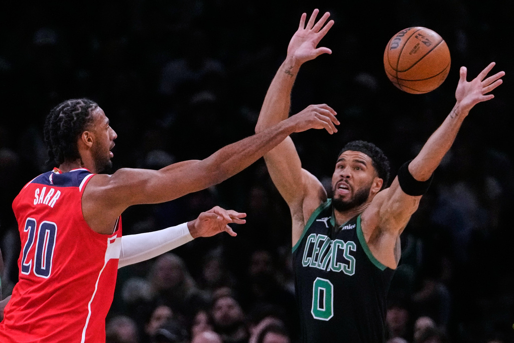 Boston Celtics forward Jayson Tatum (0) reaches up to block a pass by Washington Wizards center Alex Sarr (20) during the first half of an NBA basketball game, Saturday, March 14, 2026, in Boston. (AP Photo/Charles Krupa)