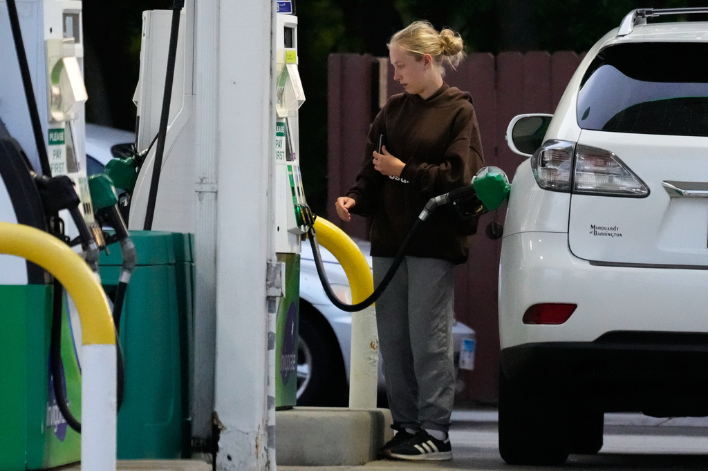 Customer checks gas price before she fills up her vehicle's tank at a gas station in Lincolnshire, Ill., Monday, June 8, 2026. (AP Photo/Nam Y. Huh)