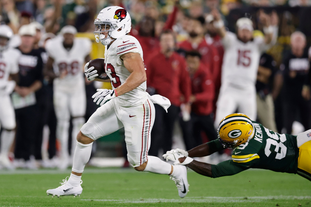 Arizona Cardinals running back Evan Hull runs past Green Bay Packers' Murvin Kenion III for a touchdown during the first half of a preseason NFL football game Friday, Aug. 28, 2026, in Green Bay, Wis. (AP Photo/Matt Ludtke)