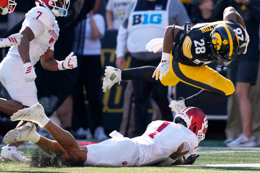 Iowa running back Kamari Moulton (28) leaps over Indiana defensive back Amare Ferrell (1) during the first half of an NCAA college football game Saturday, Sept. 27, 2025, in Iowa City, Iowa. (AP Photo/Charlie Neibergall)