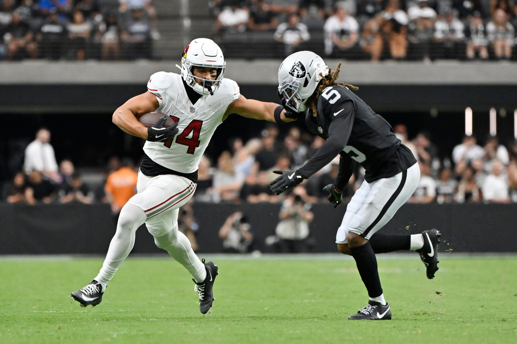Arizona Cardinals wide receiver Michael Wilson, left, runs with the ball as Las Vegas Raiders cornerback Eric Stokes (5) closes in during the first half of a preseason NFL football game, Thursday, Aug. 13, 2026, in Las Vegas. (AP Photo/David Becker)