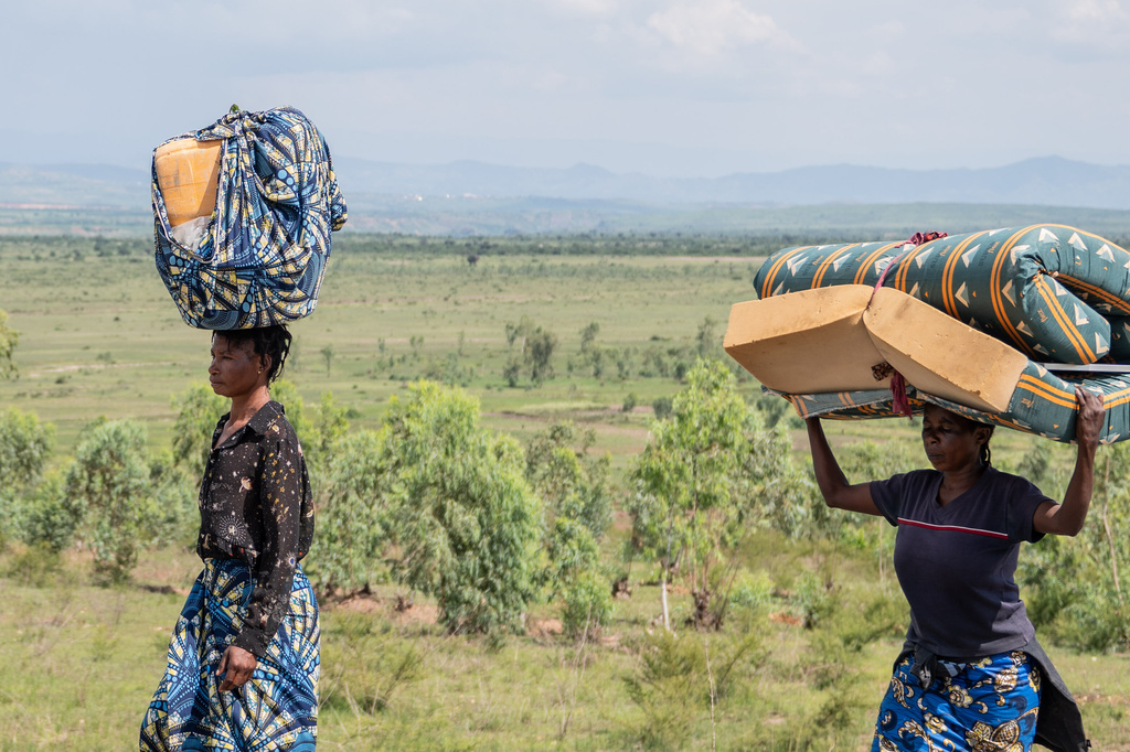 Displaced people who fled the war between FARDC and M23 rebels walk with their belongings as they return to their homes in Luvungi, Democratic Republic of Congo, Saturday, Dec. 13, 2025. (AP Photo/Moses Sawasawa)