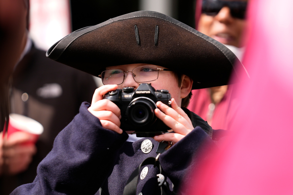 A youngster in colonial garb photographs a reenactor portraying Paul Revere, Monday, April 20, 2026, in Somerville, Mass. (AP Photo/Robert F. Bukaty)