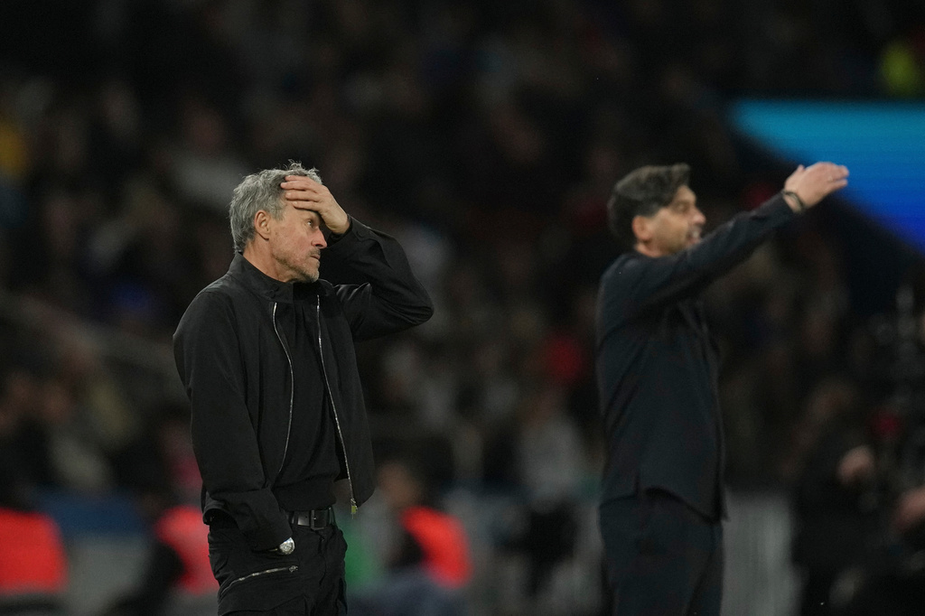 PSG's head coach Luis Enrique, left, reacts during the French League One soccer match between Paris Saint-Germain and Olympique Lyon in Paris, France, Sunday, April 19, 2026. (AP Photo/Christophe Ena)