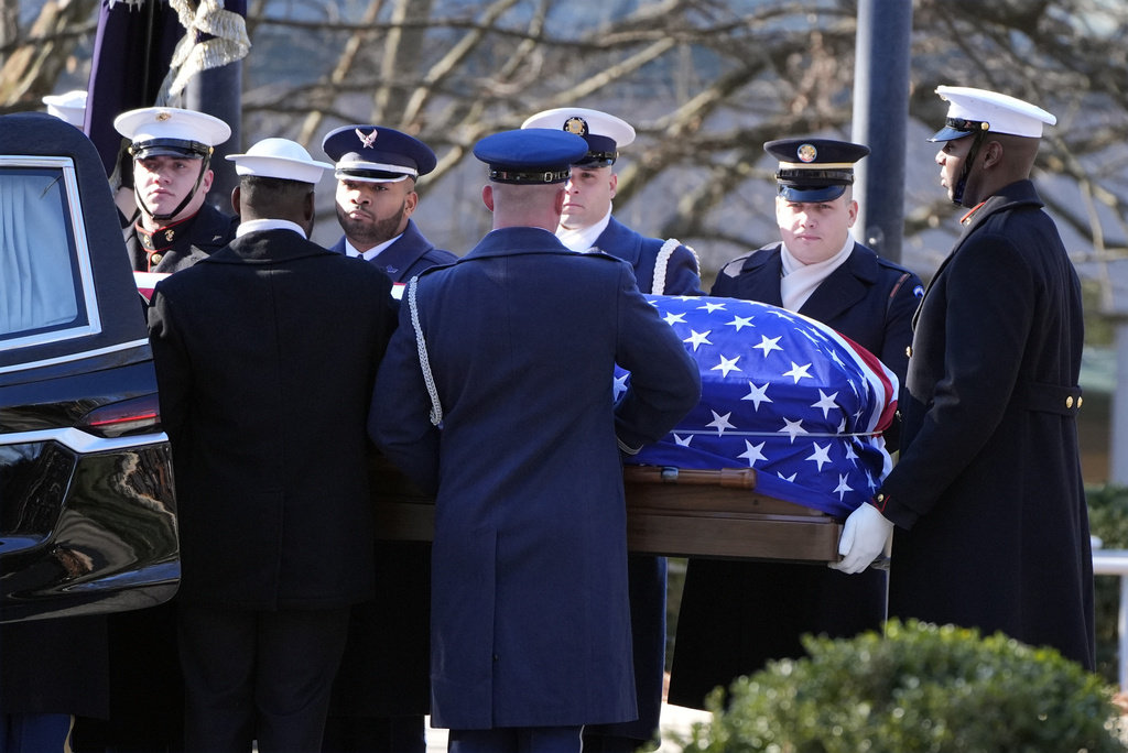 The casket of former President Jimmy Carter is placed into the hearse by a joint services body bearer team from the Jimmy Carter Presidential Library and Museum in Atlanta, Tuesday, Jan. 7, 2025. Carter died Dec. 29 at the age of 100. (AP Photo/Alex Brandon, Pool)