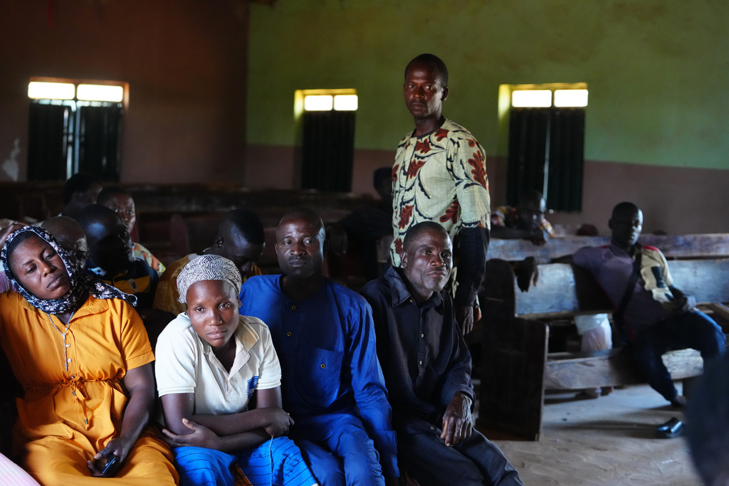 The Rev. Micah Bulus, right, standing, a pastor who was kidnapped along with others from a church service in November 2024, speaks with church members in Kaduna, northwestern Nigeria, Nov. 6, 2025. (AP Photo/Sunday Alamba)