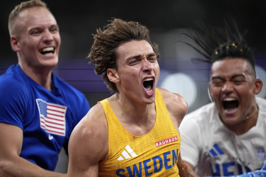 Sweden's Armand Duplantis celebrates with United States' Sam Kendricks and Greece's Emmanouil Karalis after making a clearance to break the world record after winning gold in the men's pole vault final at the World Athletics Championships in Tokyo, Monday, Sept. 15, 2025. (AP Photo/Louise Delmotte)