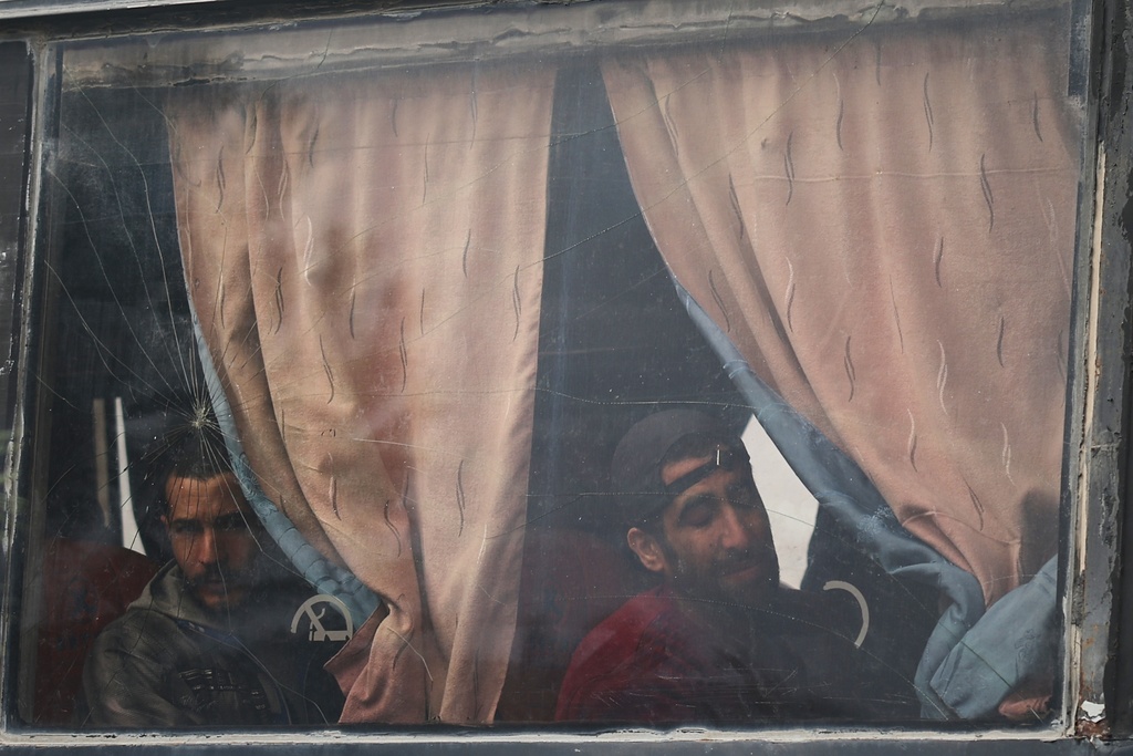 Syrian government prisoners look out from a bus after their release in a prisoner exchange between Syrian government forces and Druze militiamen in Sweida province, Syria, Thursday, Feb. 26, 2026. (AP Photo/Ghaith Alsayed)
