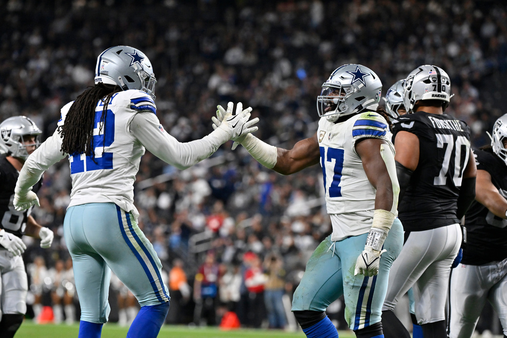 Dallas Cowboys defensive tackle Osa Odighizuwa, right, and Cowboys defensive end Jadeveon Clowney celebrate a defensive stop against the Las Vegas Raiders during the second half of an NFL football game Monday, Nov. 17, 2025, in Las Vegas. (AP Photo/David Becker)