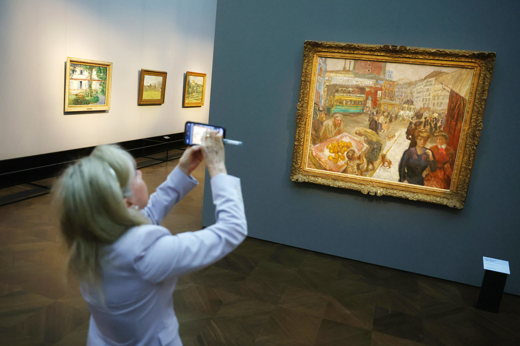 A visitor photographs the painting titled "Place Clichy" from 1867-1947 by Pierre Bonnard at a press preview for the exhibition "The Scharf Collection: Goya – Monet – Cezanne – Bonnard – Grosse" at the Alte Nationalgalerie museum in Berlin, Wednesday, Oct. 22, 2025. (AP Photo/Maryam Majd)