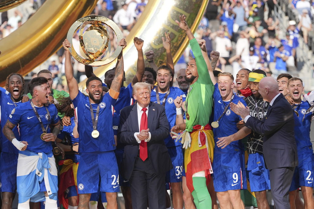 Chelsea's Reece James (24) lifts the trophy as President Donald Trump looks on following the Club World Cup final soccer match between Chelsea and PSG in East Rutherford, N.J., Sunday, July 13, 2025. (AP Photo/Seth Wenig)