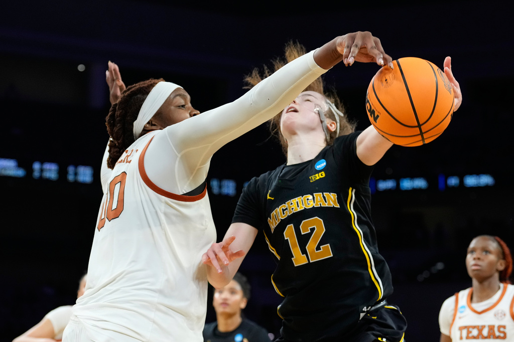 Texas center Kyla Oldacre (00) blocks a Michigan guard Syla Swords (12) shot during the second half in the Elite Eight of the NCAA college basketball tournament, Monday, March 30, 2026, in Fort Worth, Texas. (AP Photo/Tony Gutierrez)