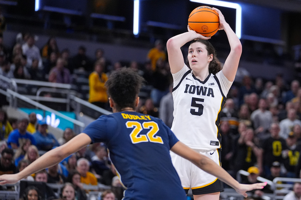 Iowa center Ava Heiden (5) shoots over Michigan forward Kendall Dudley (22) in the second half of an NCAA college basketball game in the semifinals of the Big Ten Conference tournament, Saturday, March 7, 2026 in Indianapolis. (AP Photo/Michael Conroy)