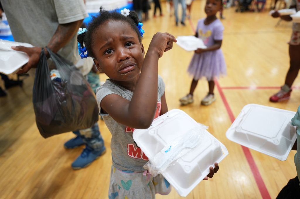 Tyanna Borom, 5, cries after receiving food at City Life Center in Gary, Indi., Thursday, Aug. 20, 2026, more than a week after a deadly storm passes through the area. (AP Photo/Nam Y. Huh)