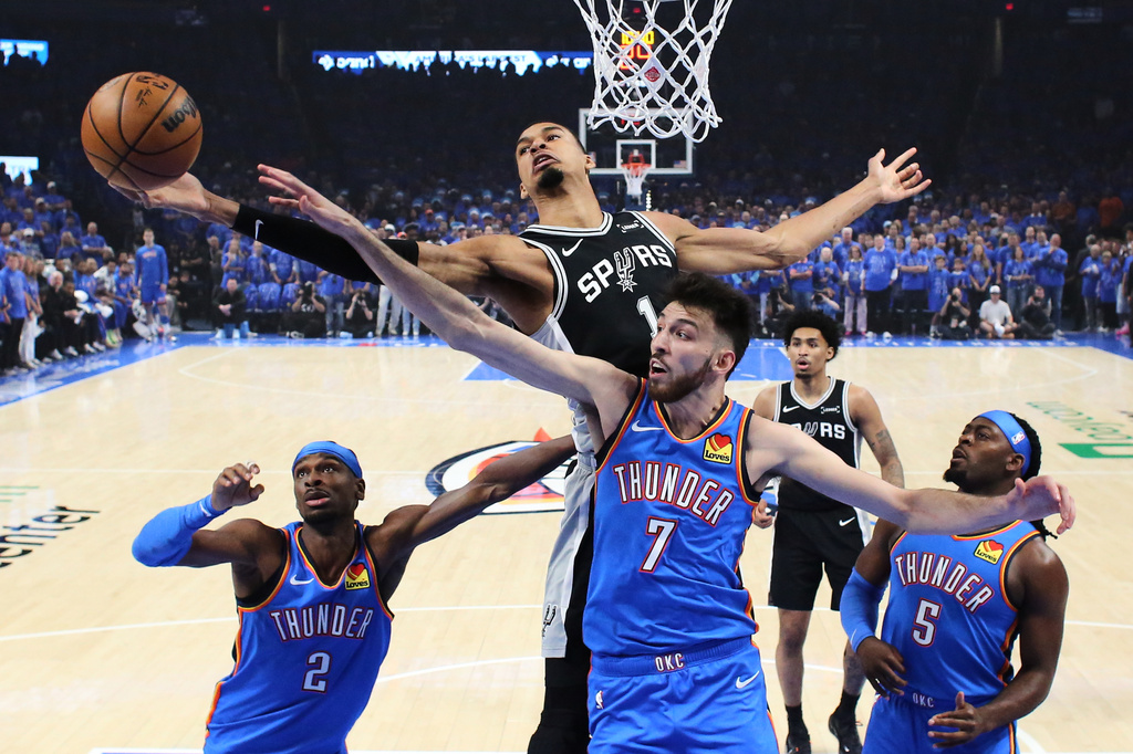 San Antonio Spurs forward Victor Wembanyama (1) and Oklahoma City Thunder center Chet Holmgren (7) reach for a rebound during the first half of Game 1 in a third-round NBA basketball playoffs series Monday, May 18, 2026, in Oklahoma City. (AP Photo/Nate Billings)