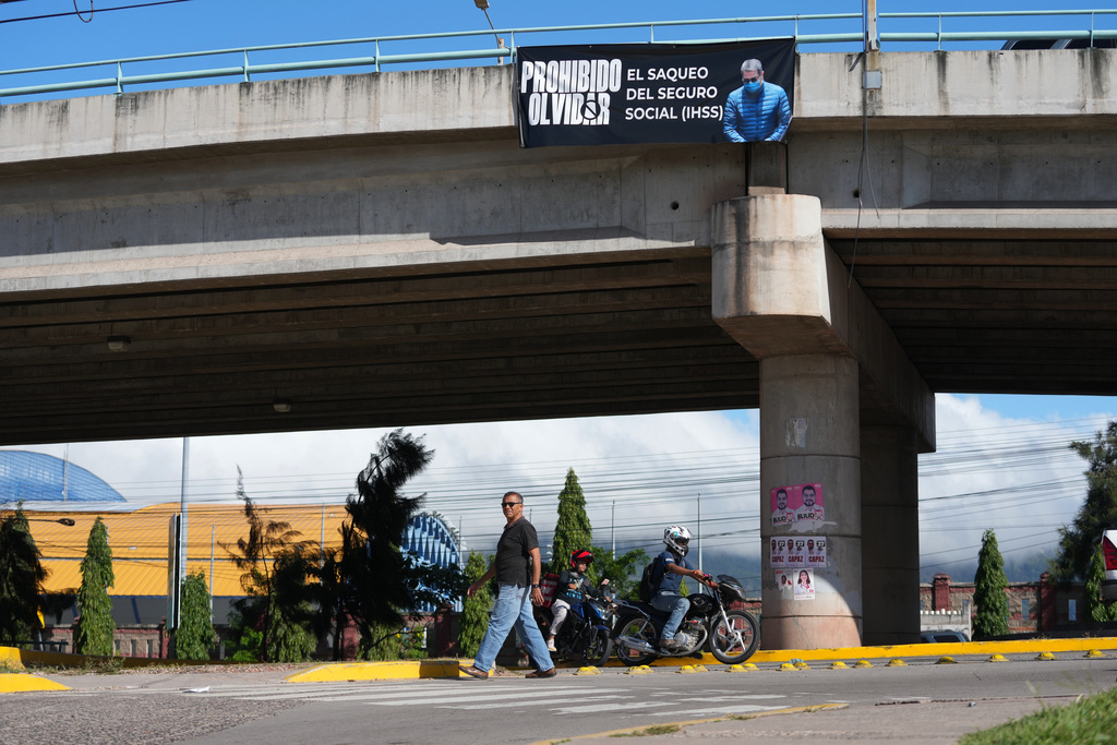 A banner with an image of former Honduran President Juan Orlando Hernandez with a message that reads in Spanish: "It is forbidden to forget the looting of social security" hangs on a bridge in Tegucigalpa, Honduras, Saturday, Nov. 29, 2025, a day after President Donald Trump said he plans to pardon Hernandez for a 2024 drug trafficking sentence. (AP Photo/Moises Castillo)
