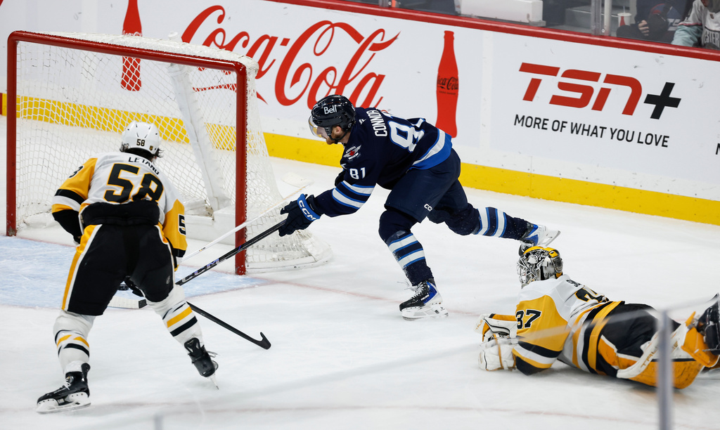 Pittsburgh Penguins goaltender Arturs Silovs (37) who was caught out of his net, throws his stick at Winnipeg Jets' Kyle Connor (81) during the second period of an NHL hockey game, Saturday, Nov. 1, 2025, in Winnipeg, Manitoba. (John Woods/The Canadian Press via AP)