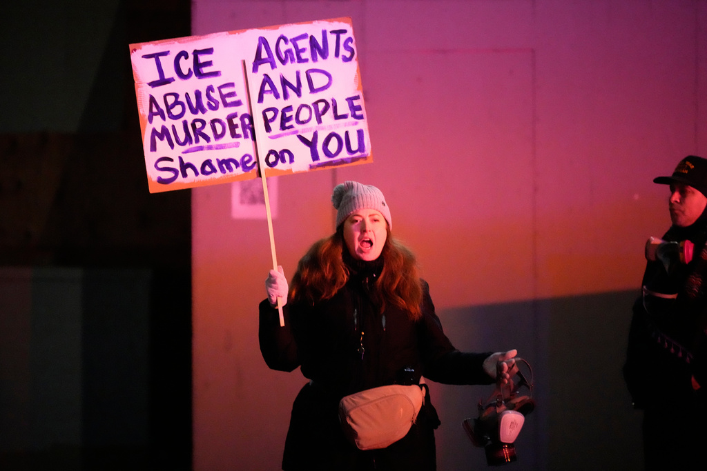 A protester holds a sign outside the U.S. Immigration and Customs Enforcement facility on Thursday, Jan. 8, 2026, in Portland, Ore. (AP Photo/Jenny Kane)
