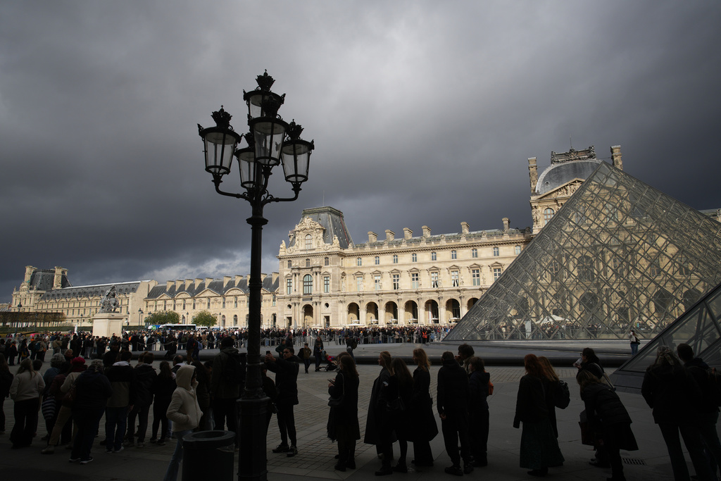 People queue to enter Le Louvre museum Monday, Oct. 27, 2025 in Paris. (AP Photo/Christophe Ena)