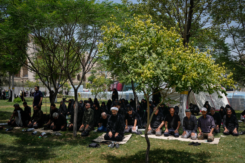 Mourners pray in the shade in a park outside the Imam Khomeini Mosalla Grand Mosque during the funeral ceremonies for the late Iranian Supreme Leader Ayatollah Ali Khamenei and members of his family in Tehran, Iran, Saturday, July 4, 2026. (AP Photo/Altaf Qadri)