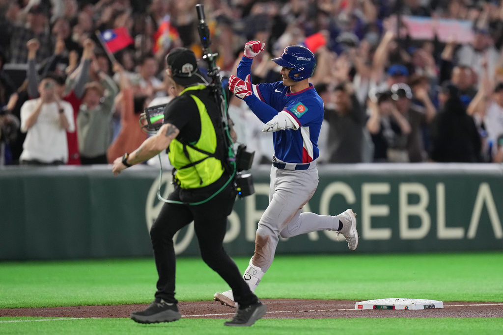 Taiwan's Stuart Fairchild runs past the third base as he calebrates his grand slam home run in the second inning of a World Baseball Classic game between Taiwan and Czechia in Tokyo, Saturday, March 7, 2026. (AP Photo/Hiro Komae)