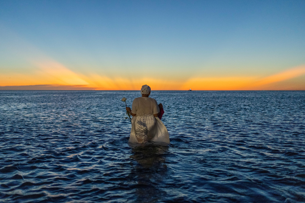 A woman wades into the waters of Ramirez Beach as part of a ritual honoring the African sea goddess Yemanja, in Montevideo, Uruguay, Feb. 2, 2025. (AP Photo/Matilde Campodonico, File)