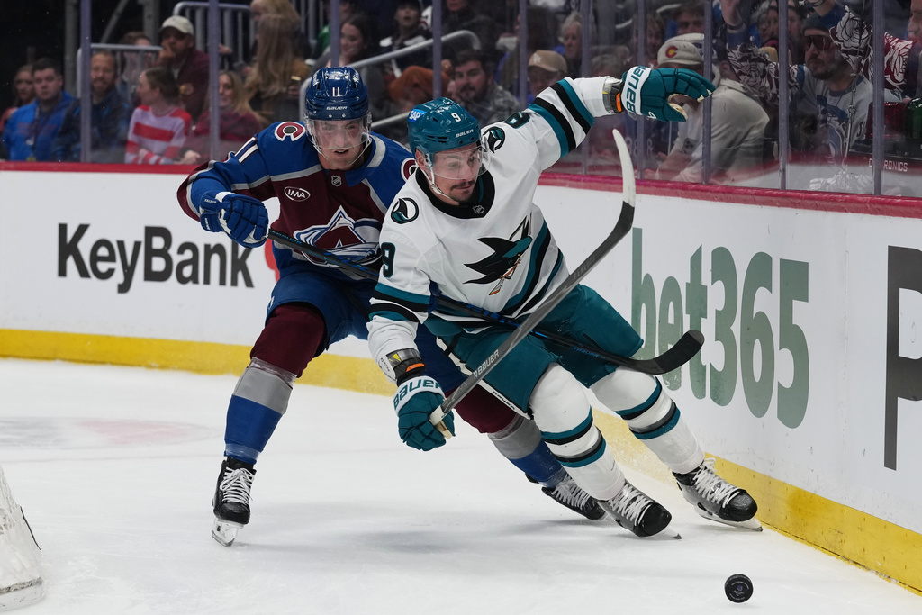 San Jose Sharks defenseman Dmitry Orlov, front, pursues the puck with Colorado Avalanche center Brock Nelson in the first period of an NHL hockey game, Wednesday, Feb. 4, 2026, in Denver. (AP Photo/David Zalubowski)