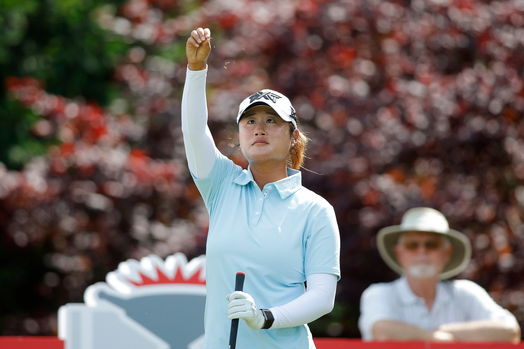 Gina Kim watches as she drops grass to check the wind before her tee shot on the 17th hole during the first round of the Dow Championship LPGA golf tournament, Thursday, June 11, 2026, at Midland Country Club in Midland, Mich. (AP Photo/Al Goldis)
