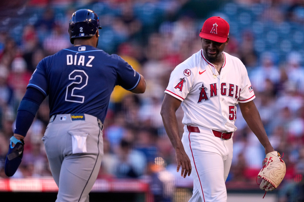 Los Angeles Angels starting pitcher José Soriano, right, and Tampa Bay Rays' Yandy Díaz greet each other after the top of the first inning of a baseball game Saturday, June 13, 2026, in Anaheim, Calif. (AP Photo/Mark J. Terrill)
