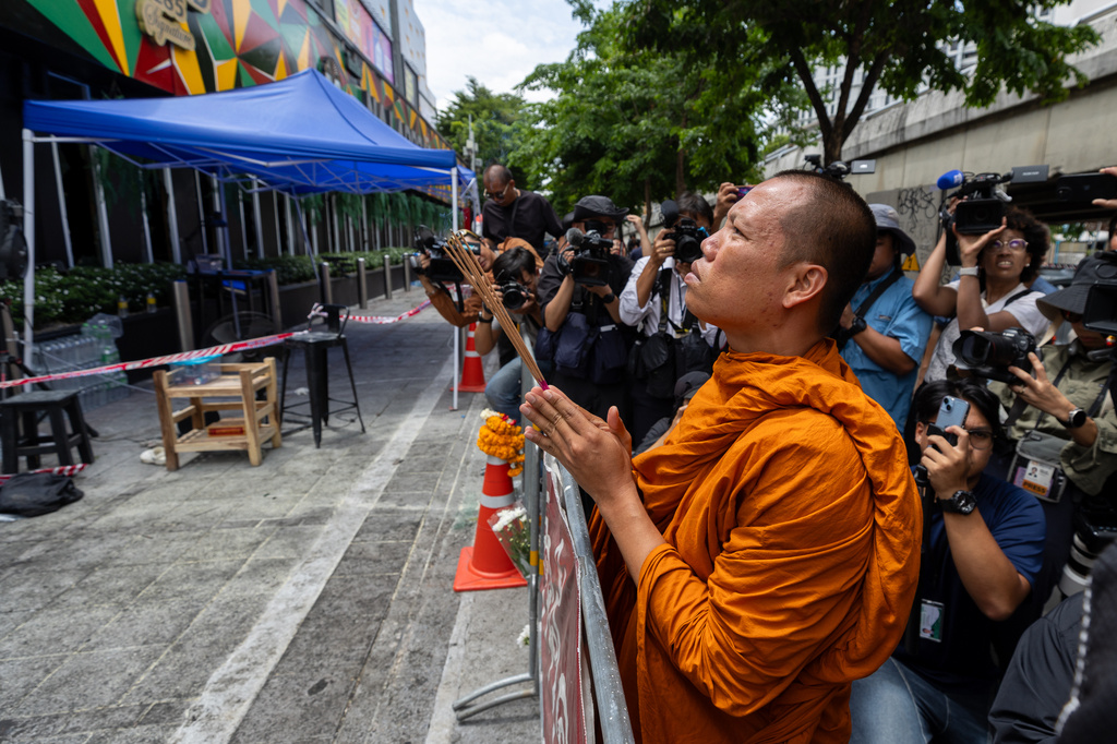 A Buddhist monk prays outside the music bar where a fire killed a number of people in Bangkok, Thailand, Tuesday, July 14, 2026. (AP Photo/Wason Wanichakorn)