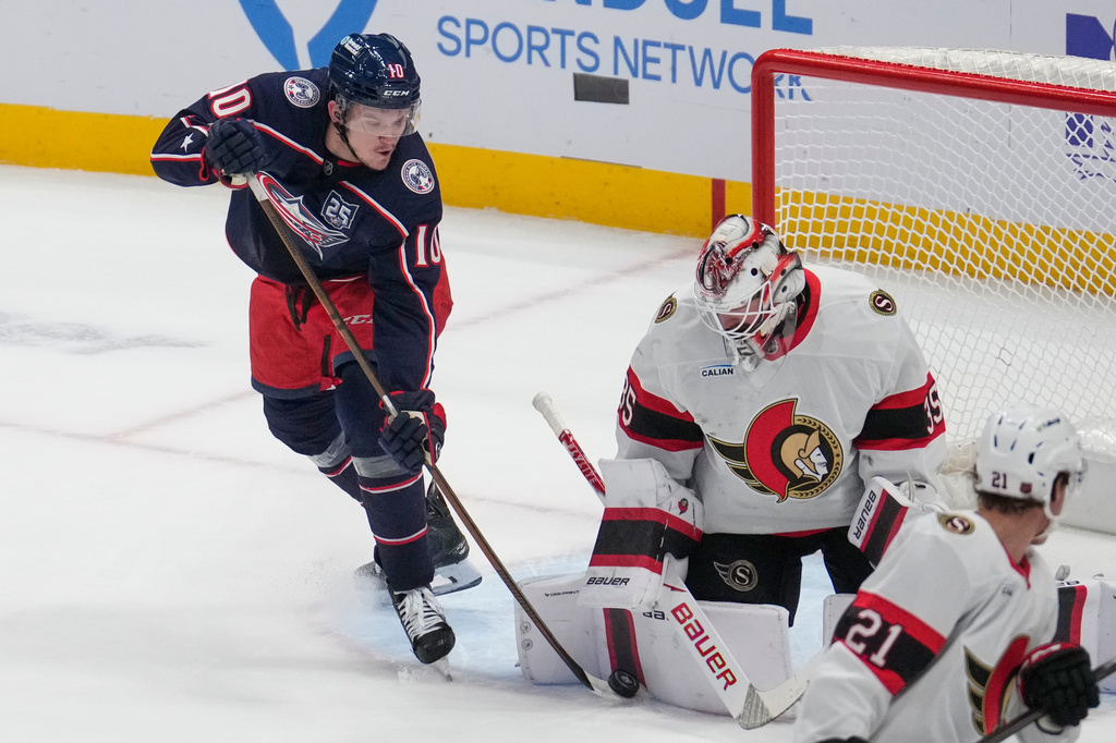 Columbus Blue Jackets left wing Dmitri Voronkov (10) reaches for the puck next to Ottawa Senators goaltender Linus Ullmark (35) in the first period of an NHL hockey game Thursday, Dec. 11, 2025, in Columbus, Ohio. (AP Photo/Sue Ogrocki)